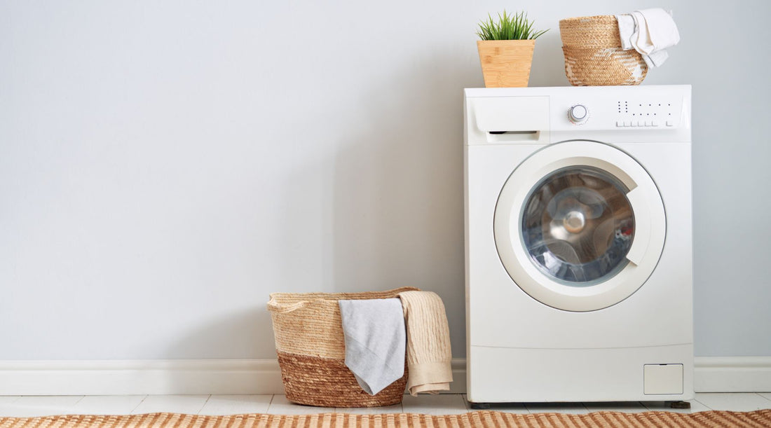 Laundry room with shirts in a basket and in the washer.
