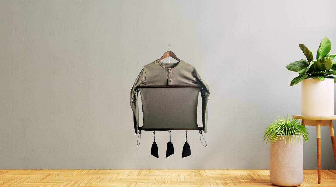 Shirt Stretcher hanging on display with two large plants to the right, highlighting its unique design.