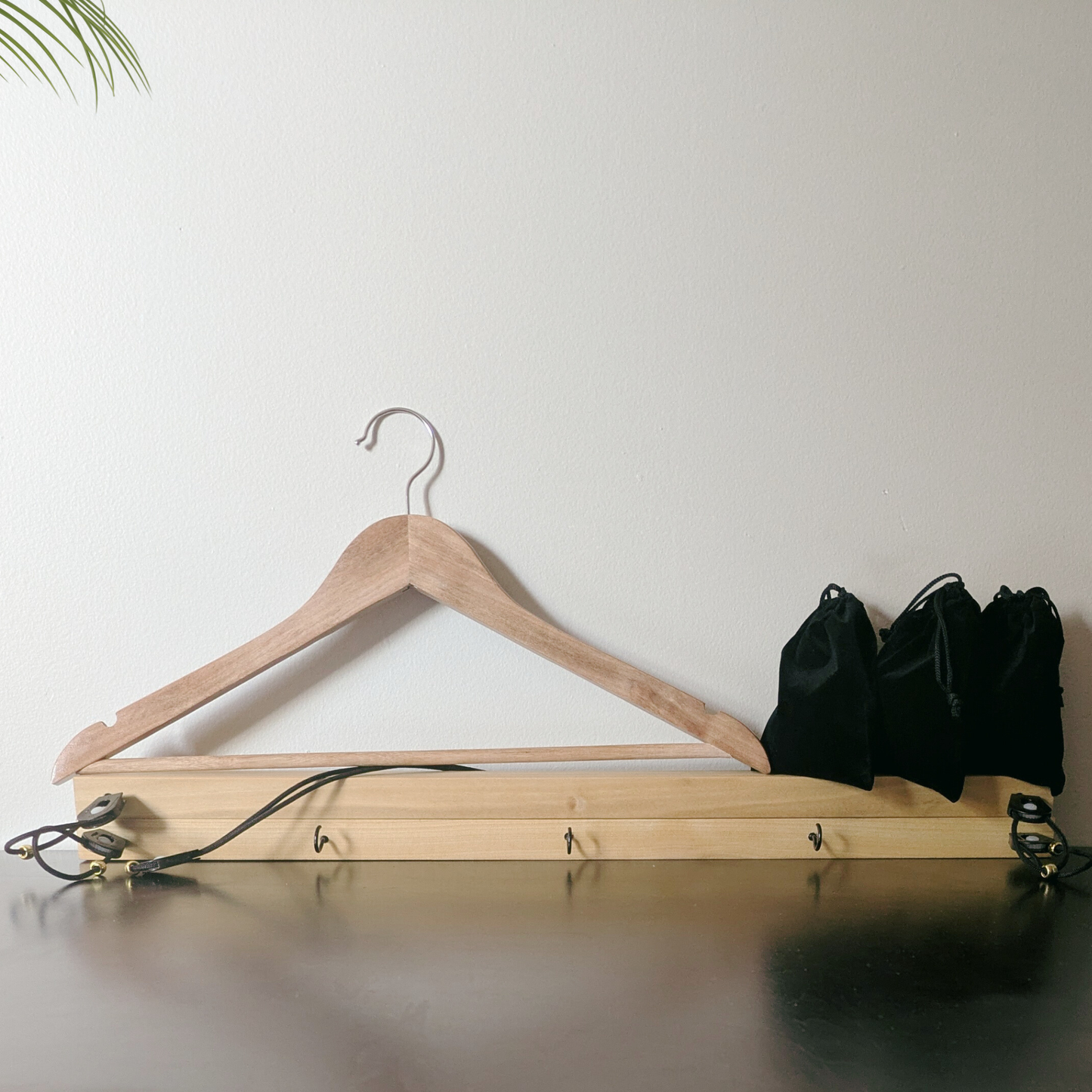 Wooden shirt stretcher resting against wall to demonstrate space-saving storage